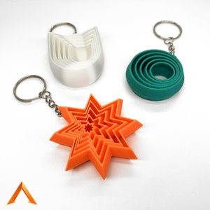 Può includere: Tre set di tagliapasta sovrapposti, ognuno con una forma diversa. Il primo set è bianco e a forma di U, il secondo set è verde e a forma di cerchio, e il terzo set è arancione e a forma di stella.