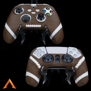 Op de afbeelding: Twee verschillende videogamecontrollers met bruine en witte voetbal-thema skins. De controllers bevinden zich op een zwarte achtergrond.