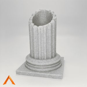 May include: A white, stone-like, decorative column with a fluted design and a square base. The column is broken at the top, creating a unique, asymmetrical shape.