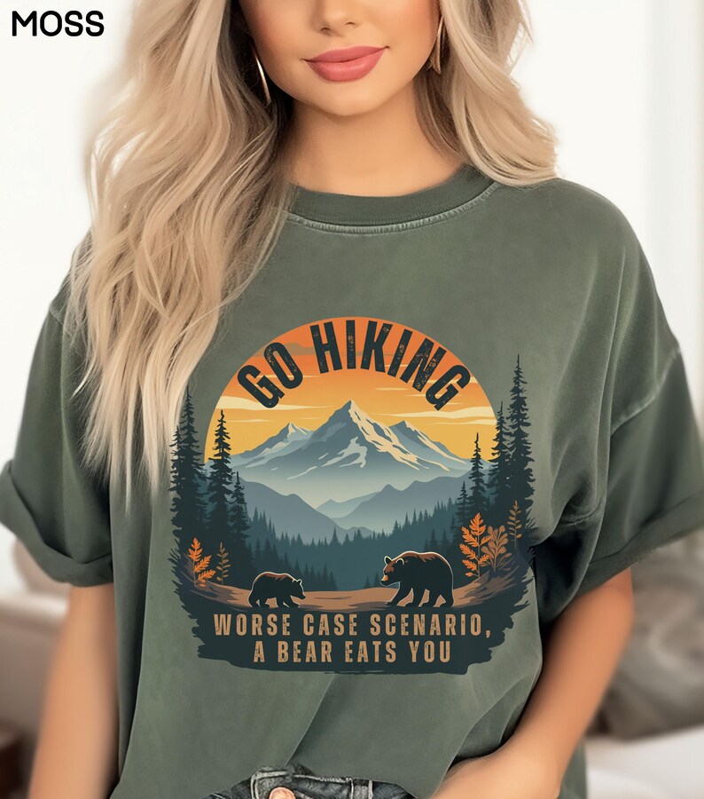 May include: Green t-shirt with a graphic of a mountain range and two bears. The graphic has the text "Go Hiking" and "Worse Case Scenario, A Bear Eats You".