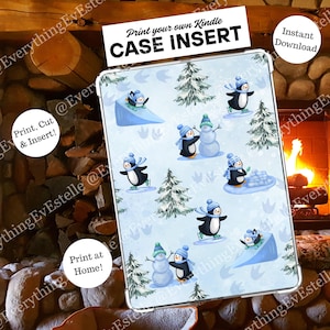 以下が含まれることがあります： 帽子とスカーフを身につけたペンギンが雪の中で遊んでいる冬のシーンが描かれたKindleケースインサート。デザインには雪だるまと松の木が薄い青色の背景に描かれています。インサートのテキストは「Print your own Kindle CASE INSERT」と書かれています。