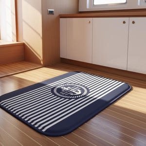 May include: A rectangular navy blue and white striped mat with a nautical anchor emblem. The mat has a rounded shape and is placed on a wooden floor. The emblem includes the text "Reef Engineer".