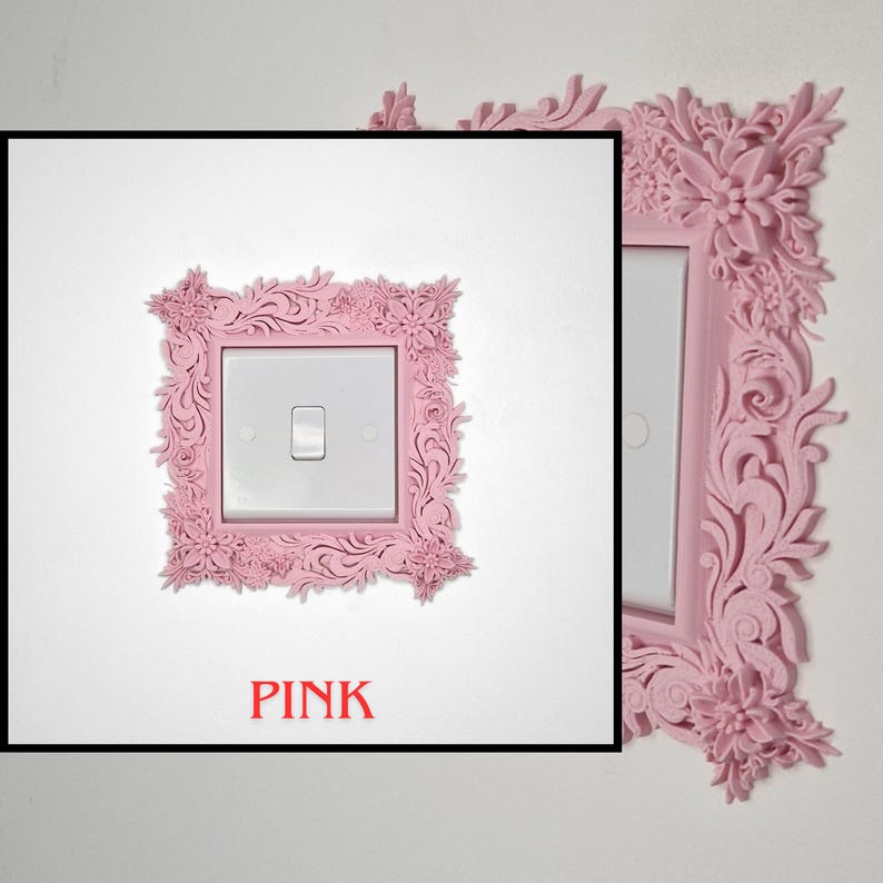 May include: A pink, ornate light switch cover with floral and scrollwork details. The cover surrounds a white light switch on a white wall. The word "PINK" is printed in red at the bottom of the image.