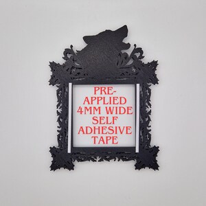 May include: Black decorative frame with a howling wolf silhouette at the top. The frame has an ornate, filigree-style design. The text "PRE-APPLIED 4MM WIDE SELF ADHESIVE TAPE" is printed in red within the frame's center.
