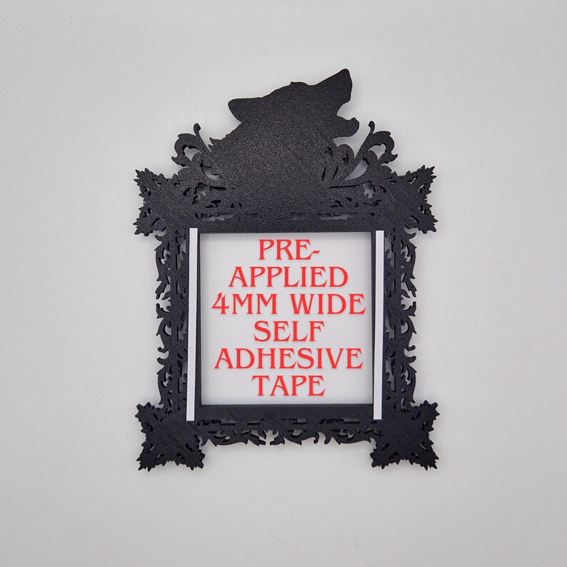 May include: Black decorative frame with a howling wolf silhouette at the top. The frame has an ornate, filigree-style design. The text "PRE-APPLIED 4MM WIDE SELF ADHESIVE TAPE" is printed in red within the frame's center.