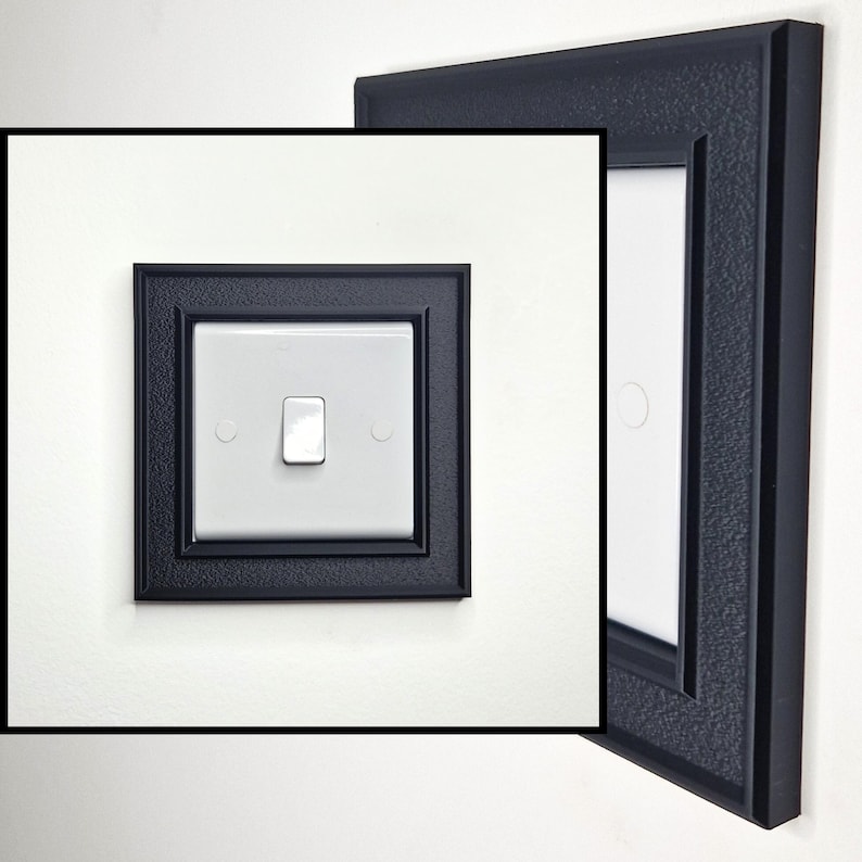 May include: A white light switch featuring a central toggle, encased in a square black frame with a textured, matte finish. The frame has a stepped, layered border design that surrounds the switch plate, providing a decorative edge.