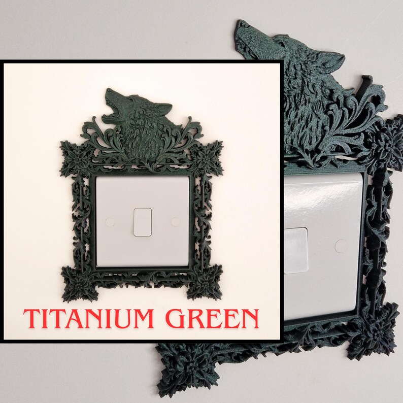 May include: Titanium green decorative light switch cover with a wolf head design. The cover has an ornate, floral-inspired frame. The text "TITANIUM GREEN" is displayed in red at the bottom of the image.