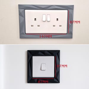 May include: A rectangular grey wall plate frame with a geometric faceted surface surrounding a white double electrical outlet, measuring 147mm by 87mm. Below, a square black faceted frame surrounds a white single light switch, measuring 87mm by 87mm.