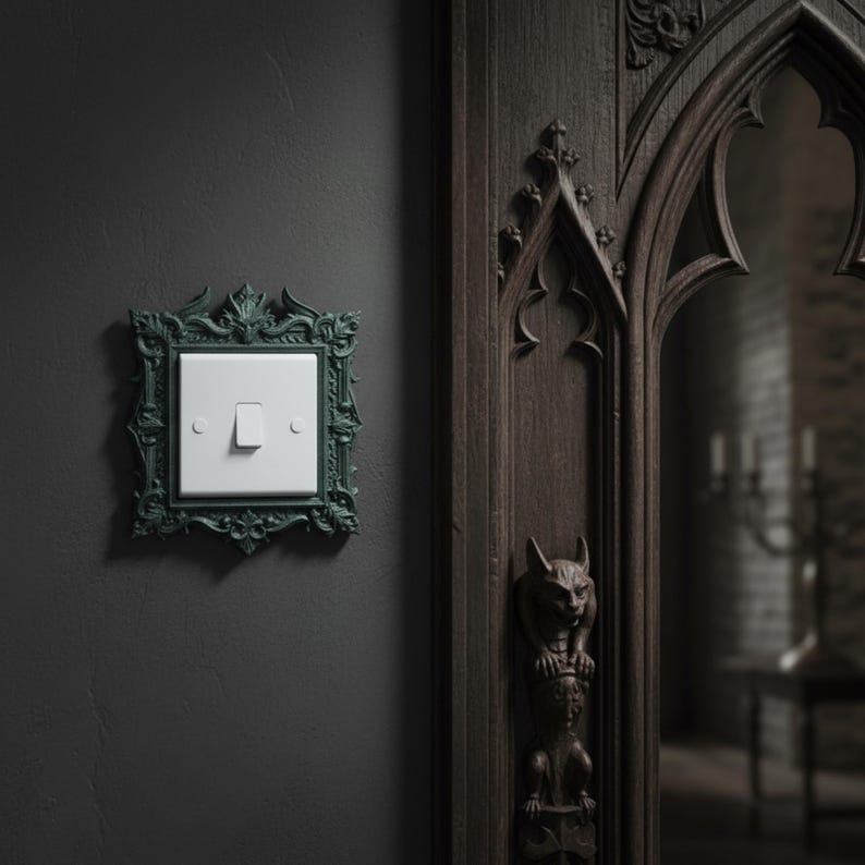May include: A dark teal, ornate light switch cover with a white switch. The cover has a detailed, gothic-style design. The switch is mounted on a dark gray wall, next to a dark wooden door with carved details.