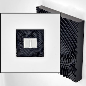 May include: A square black light switch cover featuring a textured, wavy, three-dimensional surface pattern. The cover includes two rectangular white toggle switches centered within the black frame, which has a deep, rippled, and ridged design.