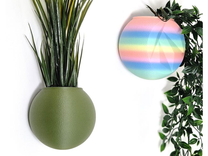 May include: Two round wall planters, one green and one with rainbow stripes. The planters are made of ceramic and have a smooth, matte finish.