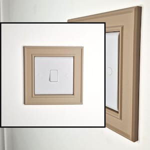 May include: A white square light switch featuring a single vertical toggle, centered within a decorative beige wall plate. The plate has a textured surface and a stepped, beveled frame design, shown from both a front-facing and a side angle.
