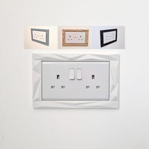 May include: A white double electrical wall socket featuring a decorative surround with a geometric, faceted surface texture. The image also displays three smaller inset versions of the same socket in grey, light brown, and black colour variations.