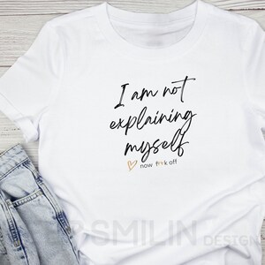 May include: White t-shirt with black text that reads "I am not explaining myself now f**k off" with a small heart symbol.