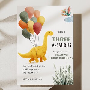 May include: A birthday invitation featuring a yellow dinosaur holding colorful balloons. The text reads "Tommy is Three A-Saurus" and includes party details: date, time, location, and RSVP information. A pterodactyl is in the upper right corner.
