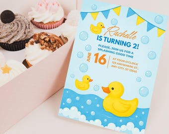 Könnte beinhalten: Eine blaue und gelbe Geburtstagseinladung mit einer Gummiente und Blasen. Die Einladung lautet "Rachelle wird 2!" und enthält das Datum "16. Juni" und die Uhrzeit "Vier Uhr".