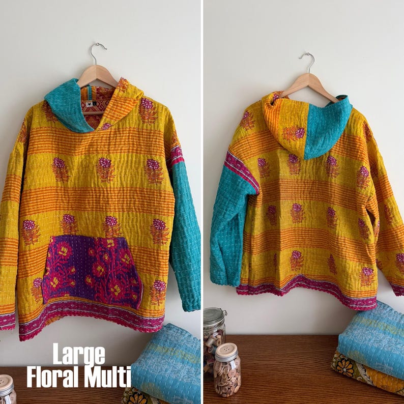 May include: A hooded sweatshirt in a floral multi-color design. The sweatshirt features a yellow and orange striped pattern with floral accents, a teal hood and sleeve, and a purple pocket. The text "Large Floral Multi" is visible.