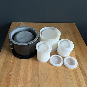 May include: A set of four round silicone moulds for making concrete planters. The moulds are in various sizes and are shown on a wooden surface.
