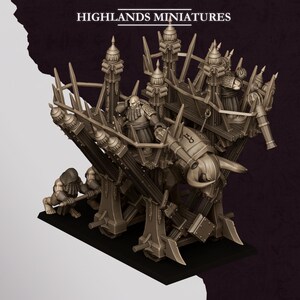 Puede incluir: Un modelo en miniatura monocromático titulado HIGHLANDS MINIATURES que presenta una gran máquina de asedio de madera tirada por figuras. La estructura incluye torres altas, un ariete central con forma de toro y varias figuras enanas.