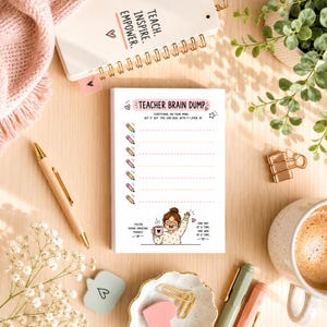 May include: A Teacher Brain Dump notepad with a cartoon illustration, pencils, and text. A spiral-bound notebook with "Teach, Inspire, Empower" is also visible. Other items include a pen, coffee cup, and decorative items.