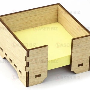 May include: A wooden desk organizer with a slot for holding sticky notes. The organizer is made of light brown wood and has a simple, modern design.