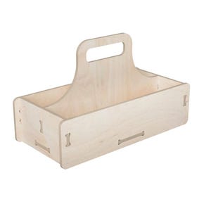 Puede incluir: Un organizador de madera de color claro con asa. La caja rectangular tiene un asa en la parte superior y está construida con juntas entrelazadas. La veta natural de la madera es visible y el diseño es simple y funcional.