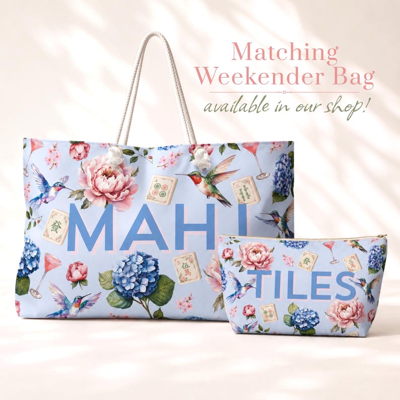 May include: A light blue tote bag and a matching zippered pouch featuring a floral pattern with hummingbirds, mahjong tiles, and cocktail glasses. The tote bag displays the text MAH and the pouch displays the text TILES in large blue letters.