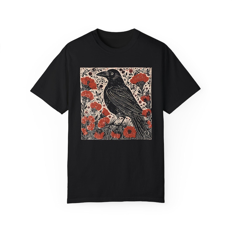May include: Black t-shirt with a graphic print of a black crow standing in a field of red flowers.