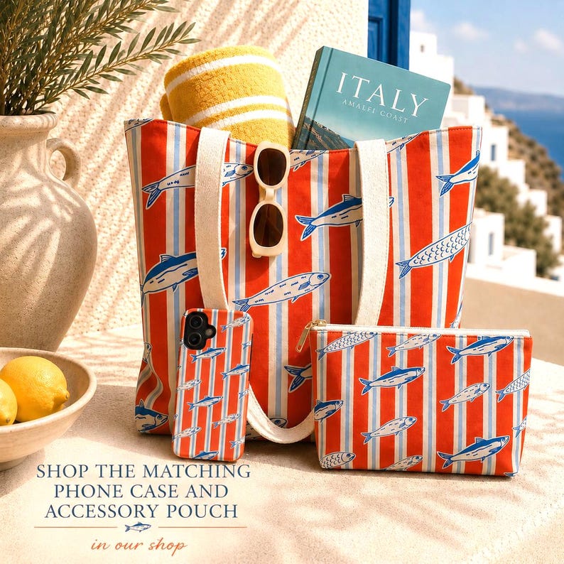 May include: A beach-themed set featuring a tote bag, phone case, and accessory pouch, all with a red and white striped pattern and fish illustrations. The tote bag holds a yellow towel, sunglasses, and a book titled "ITALY".
