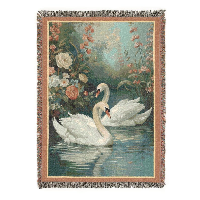 Puede incluir: Manta tejida que presenta una escena serena de dos cisnes blancos en un lago, rodeados de flores. La manta tiene un borde con flecos y una paleta de colores de azules, verdes y rosas suaves, creando una est&eacute;tica vintage.