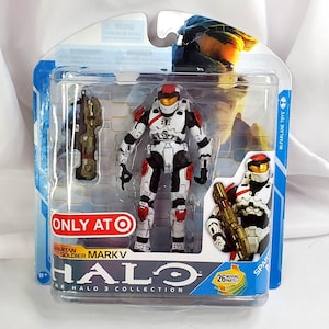 May include: A Halo 3 Collection Spartan Soldier Mark V action figure in a clear plastic package. The figure is white, red, and black, with a gold helmet and weapon. The package includes the text "ONLY AT TARGET".