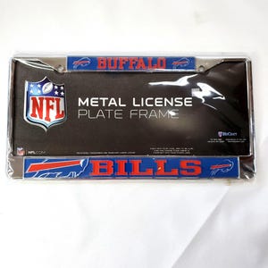 May include: A metal license plate frame featuring the Buffalo Bills NFL team logo. The frame has a black background with the team name and logo in red and blue. The NFL logo is also visible.