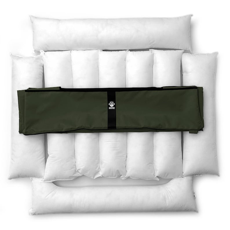 May include: A dog bed set featuring a white, quilted base and bolster pillows. The set includes a dark green, rectangular cover with a black strap and a logo. The bed is designed for pet comfort and support.