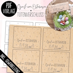 Puede incluir: Una hoja de papel kraft con cuatro etiquetas rectangulares, cada una con el texto "Gruß vom Osterhasen" y una pequeña ilustración de conejito. Las etiquetas son para embalaje temático de Pascua. La imagen también incluye una plantilla PDF.