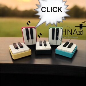 May include: A collection of miniature piano key sets in various colors, including red, yellow, green, and blue. Each set features black and white keys. The word "CLICK" is in a speech bubble above the objects.