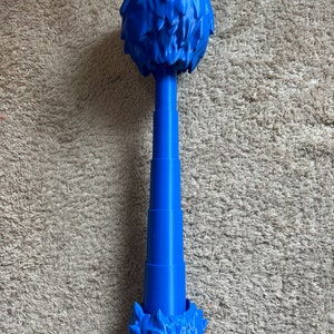 Può includere: Un giocattolo di plastica blu a forma di albero con una cima rotonda e un tronco segmentato.