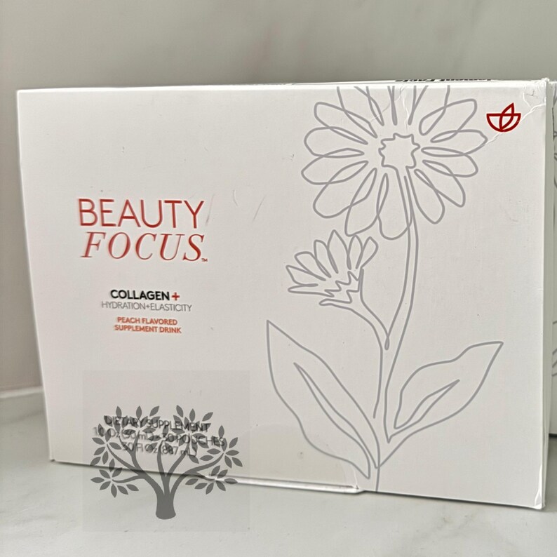 Puede incluir: Caja blanca con un dise&ntilde;o de flor estilizado y el texto "BEAUTY FOCUS" en rojo y negro. La caja tambi&eacute;n tiene el texto "COLLAGEN + HYDRATION + ELASTICITY" y "PEACH FLAVORED SUPPLEMENT DRINK" en negro.