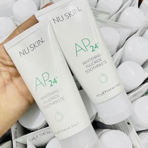 May include: Two white tubes of Nu Skin AP24 Whitening Fluoride Toothpaste. The tubes are labeled with the brand name and product name in green and black text. The tubes are 110 grams (4 ounces) each.