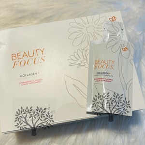 Puede incluir: Una caja de Beauty Focus Collagen+ Hydration Elasticity Sabor a Fresa Complemento Alimenticio L&iacute;quido. La caja es blanca con un dise&ntilde;o floral y el texto "Beauty Focus" en naranja y negro. La caja contiene 30 sobres individuales del complemento.