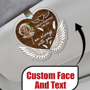 May include: A wooden heart-shaped car sunshade with a photo frame, white angel wings, and the text "I am always with you". The text "Ashley Martinez 1955-2025" is also included.