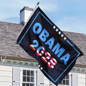 May include: A black flag with a blue border and white stars. The text "OBAMA 2028" is written in blue and red letters.