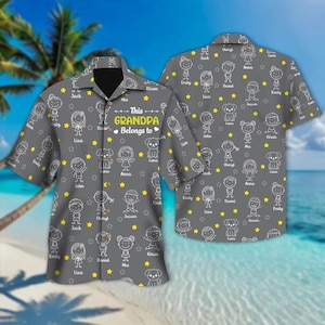 May include: Grey button-down shirt featuring a pattern of stick figures, stars, and dogs. The shirt has the text "This Grandpa Belongs to" above a list of names. The shirt is short-sleeved and has a collar.