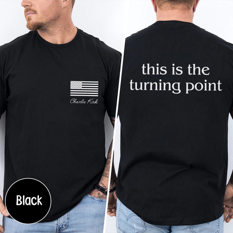May include: Black t-shirt with a white American flag graphic and the name "Charlie Kirk" printed below it. The back of the shirt features the text "this is the turning point" in white. The shirt is a crew neck.