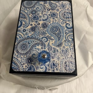 May include: A blue and white paisley patterned wooden box with a blue knob. The box has a black border.