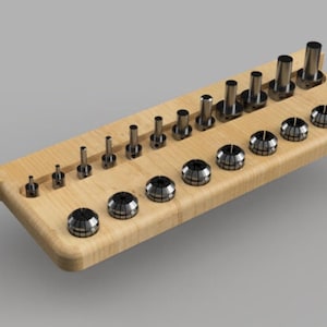 May include: A wooden storage rack with slots for holding a variety of metal collet chucks. The rack is made of light brown wood and has a rounded edge. The chucks are silver and have a variety of sizes.