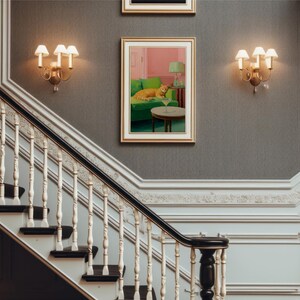 May include: A detailed interior shot featuring a staircase with a decorative balustrade and dark wood steps. The walls are grey, with sconces and framed artwork. A painting shows a cat on a green sofa with a cocktail.
