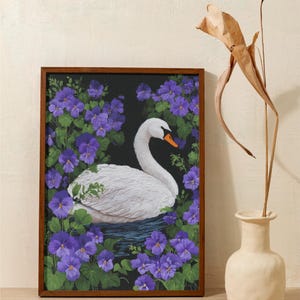 Op de afbeelding: Een ingelijst schilderij van een witte zwaan met een oranje snavel, omringd door paarse viooltjes en groene bladeren tegen een zwarte achtergrond. Het kunstwerk zit in een bruine houten lijst en wordt op een lichtgekleurd oppervlak getoond.