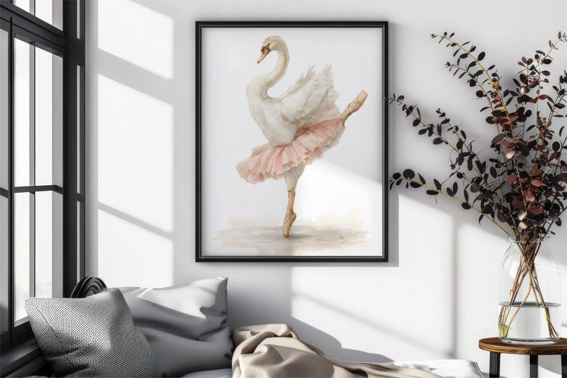 May include: Framed watercolour print of a swan in a ballet pose. The swan is white with a peach-coloured tutu and is set against a neutral background. The artwork is displayed in a black frame.