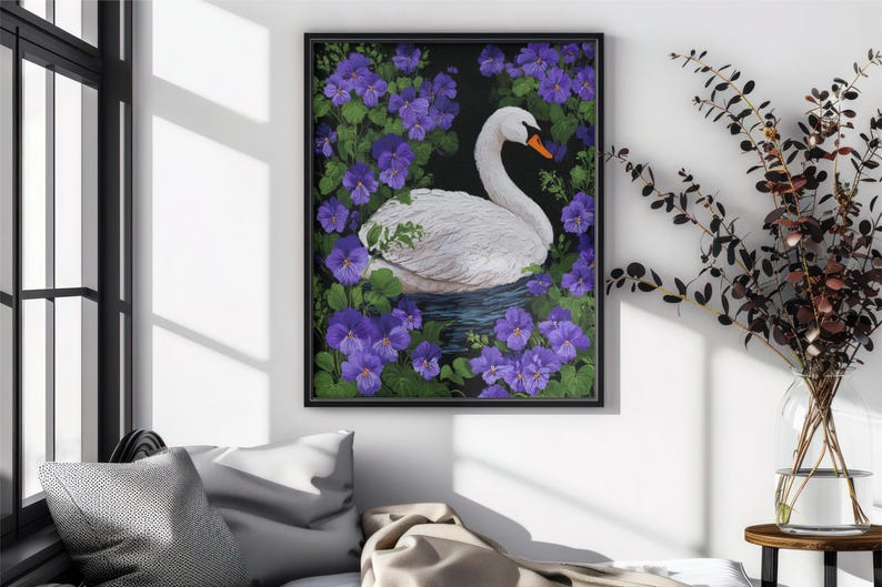 Op de afbeelding: Een ingelijste kunstdruk met een witte zwaan met een oranje snavel, omringd door paarse bloemen en groene bladeren. Het kunstwerk staat op een donkere achtergrond, de lijst is zwart. Thema: natuur.