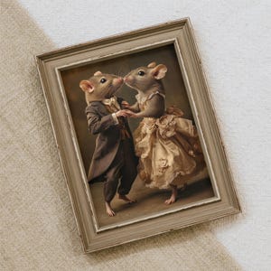 Puede incluir: Una pintura enmarcada de dos ratones vestidos con atuendos formales. El ratón macho lleva un traje marrón y una pajarita blanca. La ratona lleva un vestido blanco con ribete de encaje y un estampado floral. Los ratones están bailando y mirándose el uno al otro.